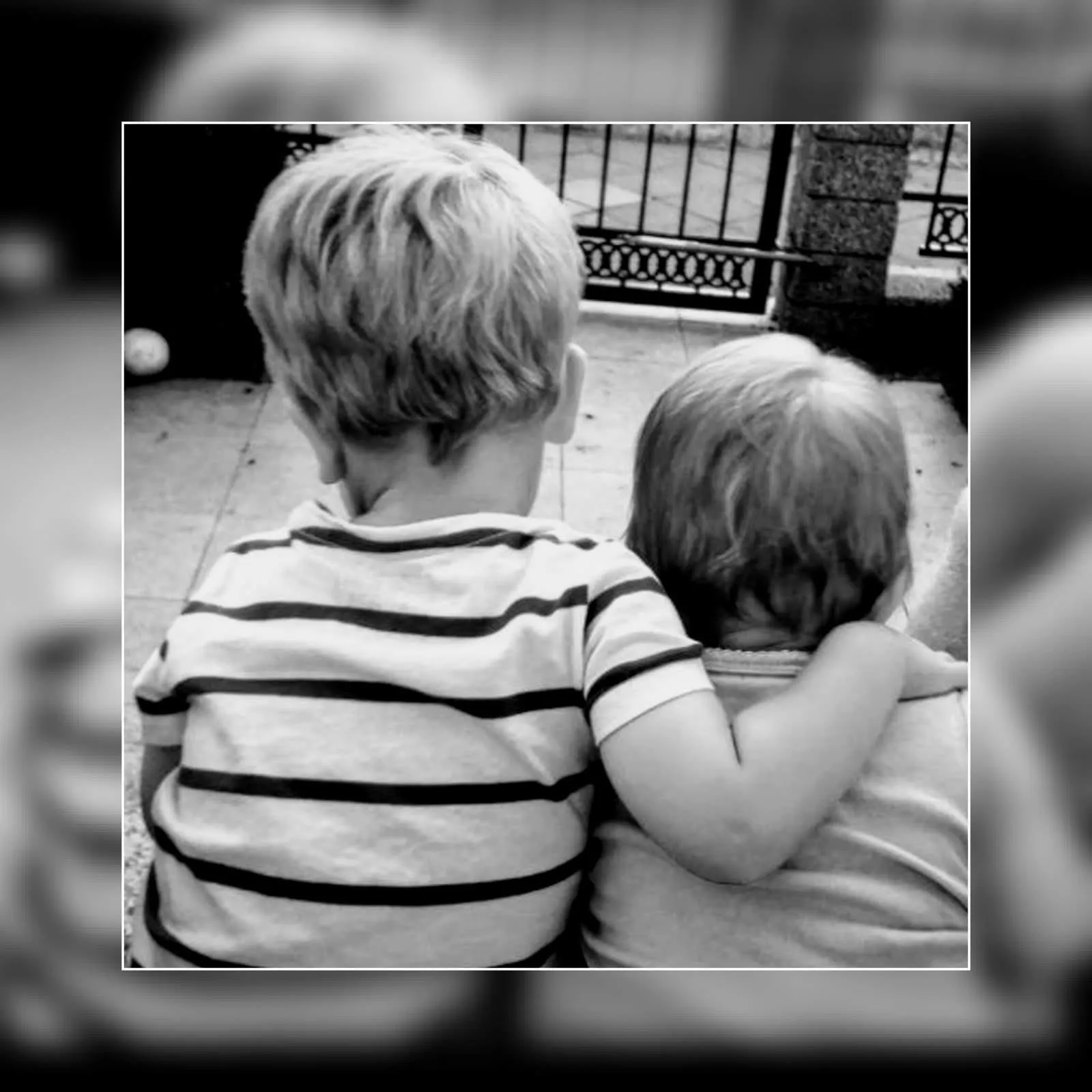 Zwei Kinder sitzen von hinten gesehen eng beieinander